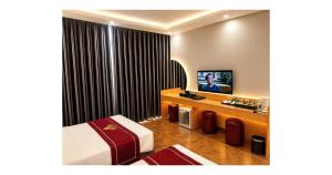 a hotel room with a bed and a flat screen tv at Rosy Hotel 8 in Yên Lô