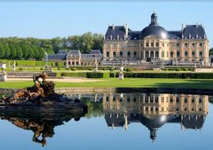 a large house with a reflection in the water at Maison Familiale - 7 personnes - Parking privé & Jardin - Disney 24 min in Tournan-en-Brie