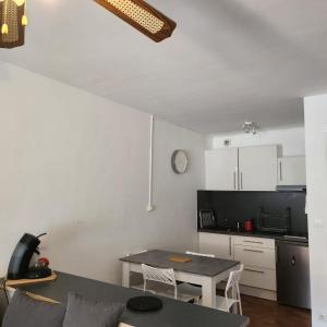 a living room with a table and a kitchen at Studio avec grande terrasse in Carnon-Plage