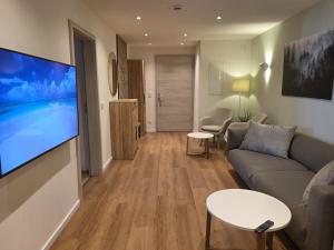 a living room with a couch and a flat screen tv at Ferienwohnungen Hirschen in Löffingen