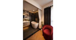 a bathroom with a red chair and a bath tub at Rosy Hotel 8 in Yên Lô