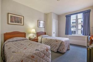 una camera d'albergo con due letti e una finestra di Hotel Harrington a Washington