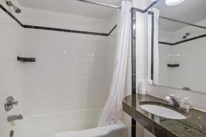 un bagno con lavandino, vasca e doccia di Hotel Harrington a Washington Altre 72 foto
