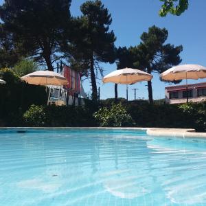 una piscina con due ombrelloni di Rural Arco Iris a Cuenca
