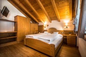 un grande letto in una stanza con soffitto in legno di Ciasa Montanara a La Villa