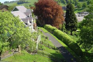 an aerial view of a house with a fence and trees at Lovely cottage in garden grounds near centre in Jedburgh