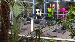 a row of chairs in a building with plants at Hôtel Le Méditerranée in Lourdes +36 photos