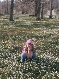 a little girl sitting in a field of flowers at Lugnt läge för 1-4 in Frillesås