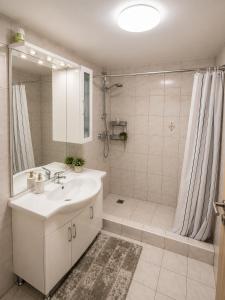 a white bathroom with a sink and a shower at Bungalow Perun in Blejska Dobrava