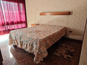 a bedroom with a bed with a comforter on it at Magisterio in Arica