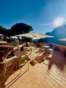 a patio with tables and chairs and umbrellas at La Dimora Di Roberta in Montalcino
