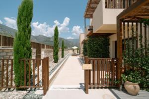 a walkway in front of a building with trees at Atman Eco Lodge in Gliki