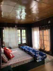 a bedroom with a bed in a room with windows at Larikha stay chumpa in Leh