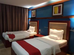 two beds in a hotel room with blue walls at Cherry Midtown Hotel in Bahac-bahac +76 photos