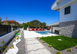 a backyard with a swimming pool and a house at Dolunay Villas - 2 in Dalyan