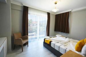 a bedroom with a bed and a chair and a window at Dolunay Villas - 2 in Dalyan