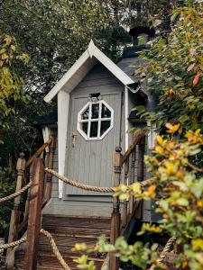 a gray bird house with a window on the stairs at 4 Walkers Cottage - Cosy, dog friendly with private unique BBQ hut! in Pont Sticill