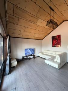 a living room with white furniture and a wooden ceiling at СвояХата in Svityazʼ