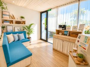 a room with a blue couch and a window at 湛藍海岸民宿 Azure-墾丁南灣沙灘-可包棟-國旅卡 in Nanwan