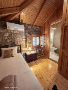 a bedroom with a bed and a stone wall at Kefalonian Luxury Villas in Kástron +111 photos