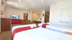 a hotel room with two beds and a television at J2 Hotel in Mae Sot