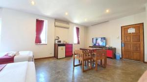 a room with a bed and a table and a television at J2 Hotel in Mae Sot