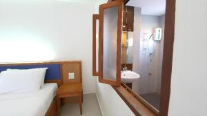 a bathroom with a bed and a sink and a mirror at J2 Hotel in Mae Sot +52 photos