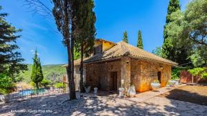 an old stone house with a tree in front of it at Kefalonian Luxury Villas in Kástron