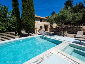 a swimming pool in front of a stone house at Kefalonian Luxury Villas in Kástron