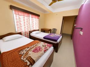 a room with two beds and a purple door at DAS HOTEL in Darjeeling