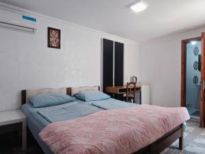 a bedroom with a bed and a desk in it at Guesthouse Mery in Kobuleti