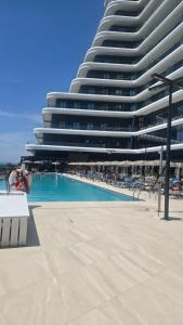 a large building with a swimming pool in front of a building at Eddy's Luxury Suites - Ilyonis in Shëngjin