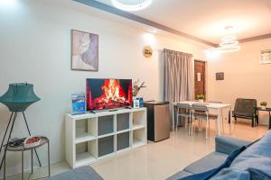 a living room with a couch and a tv and a table at Manzil Anilao B&B in Mabini