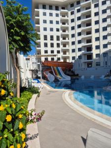 a swimming pool with a slide next to a building at Luxury apartment with panoramic sea view ruby in Alanya