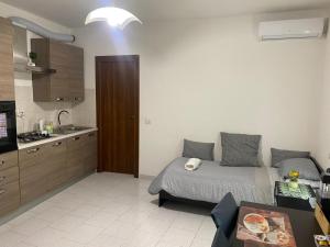 a bedroom with a bed and a kitchen with a sink at Matì Malpensa con navetta 25eur in Lonate Pozzolo