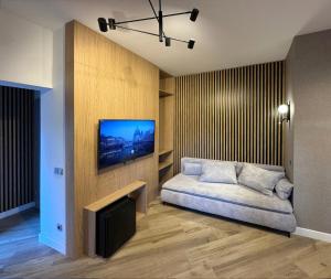 a living room with a couch and a flat screen tv at Pensjonat Kotwica in Kuźnica