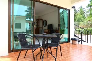 a patio with a table and chairs on a balcony at First light beach hin kong in Hinkong