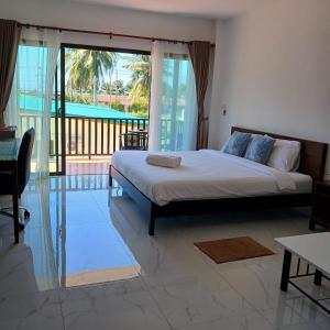a bedroom with a bed with a view of a balcony at First light beach hin kong in Hinkong