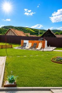 ein Garten mit Liegestühlen im Rasen in der Unterkunft Sunset Oasis in Dătăşeni