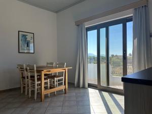 a dining room with a table and chairs and a window at Blue Sky in Frangokastello