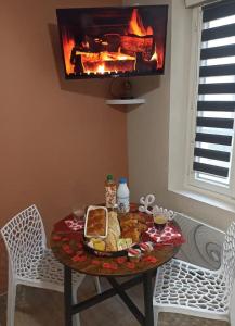 a table with a plate of food on it with a fireplace at Le Rêve Bulle in Abbeville