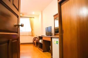 a room with a desk with a computer and a deskicterictericterswersswers at Phuthong Place in Phayao