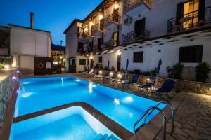 a swimming pool in front of a hotel at night at Hotel Nostos in Nydri