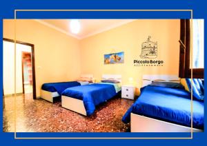 two beds in a room with blue sheets at Piccolo Borgo Affittacamere BIKE FRIENDLY in Taranto