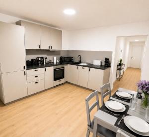 a kitchen with white cabinets and a table with chairs at Apartment -Wohnung Herford in Herford +5 photos