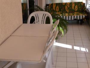 two white chairs and a table and a couch at Chambre chez l'habitant Nice Baie des Anges in Nice