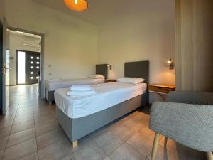 a hotel room with two beds and a chair at Blue Sky in Frangokastello +53 photos