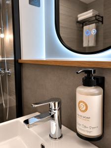 a bottle of soap sitting on a bathroom sink at Kyriad Direct Le Bourget Gonesse in Gonesse