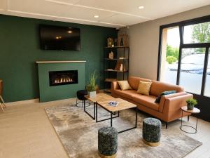 a living room with a couch and a fireplace at Kyriad Direct Le Bourget Gonesse in Gonesse