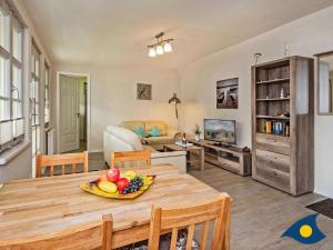 a living room with a table with a bowl of fruit on it at Villa Livia Whg 13 in Ahlbeck